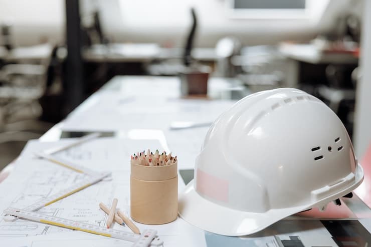 Architect drawings and hardhat on a table